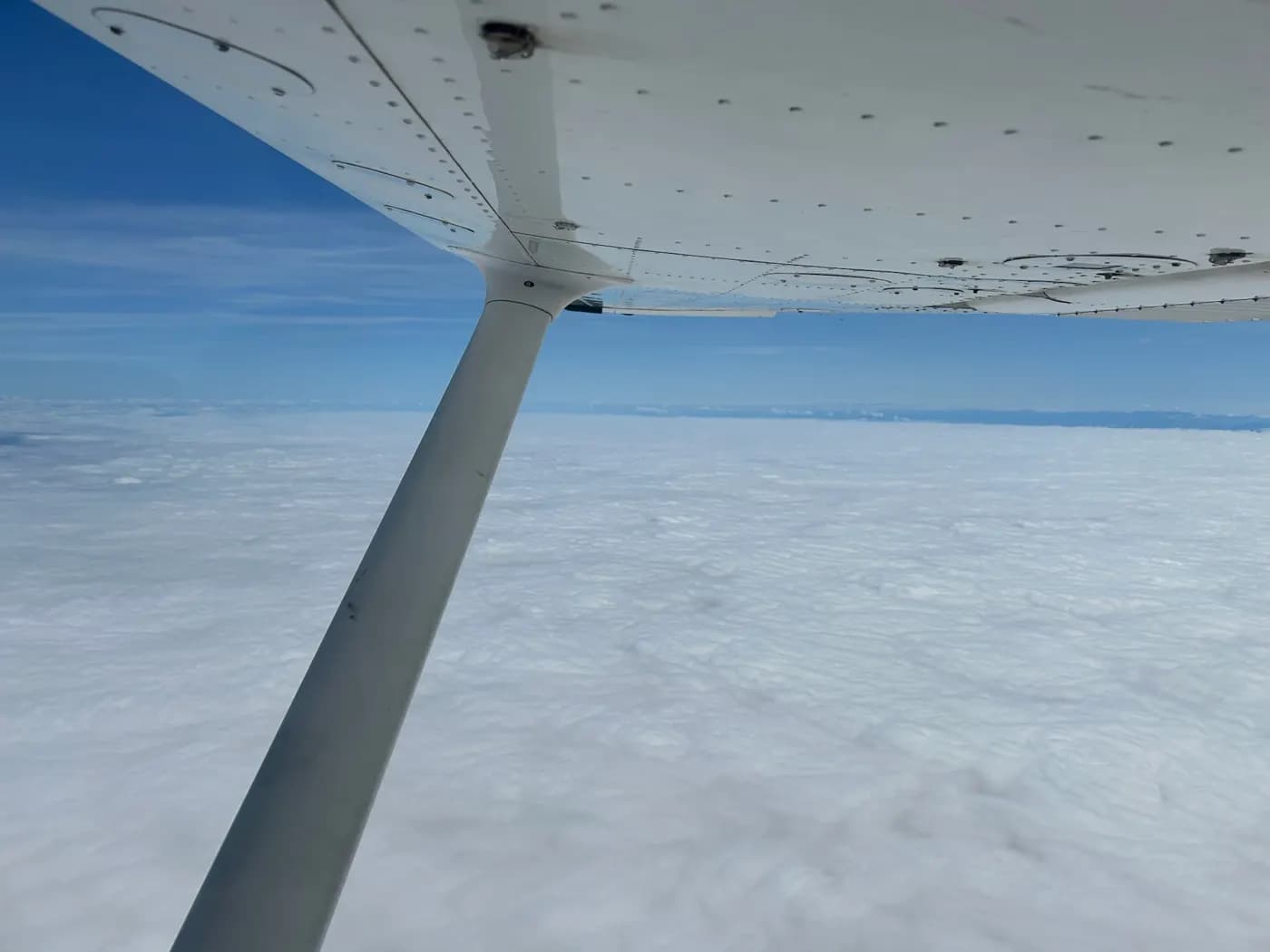Wing strut above a sea of clouds