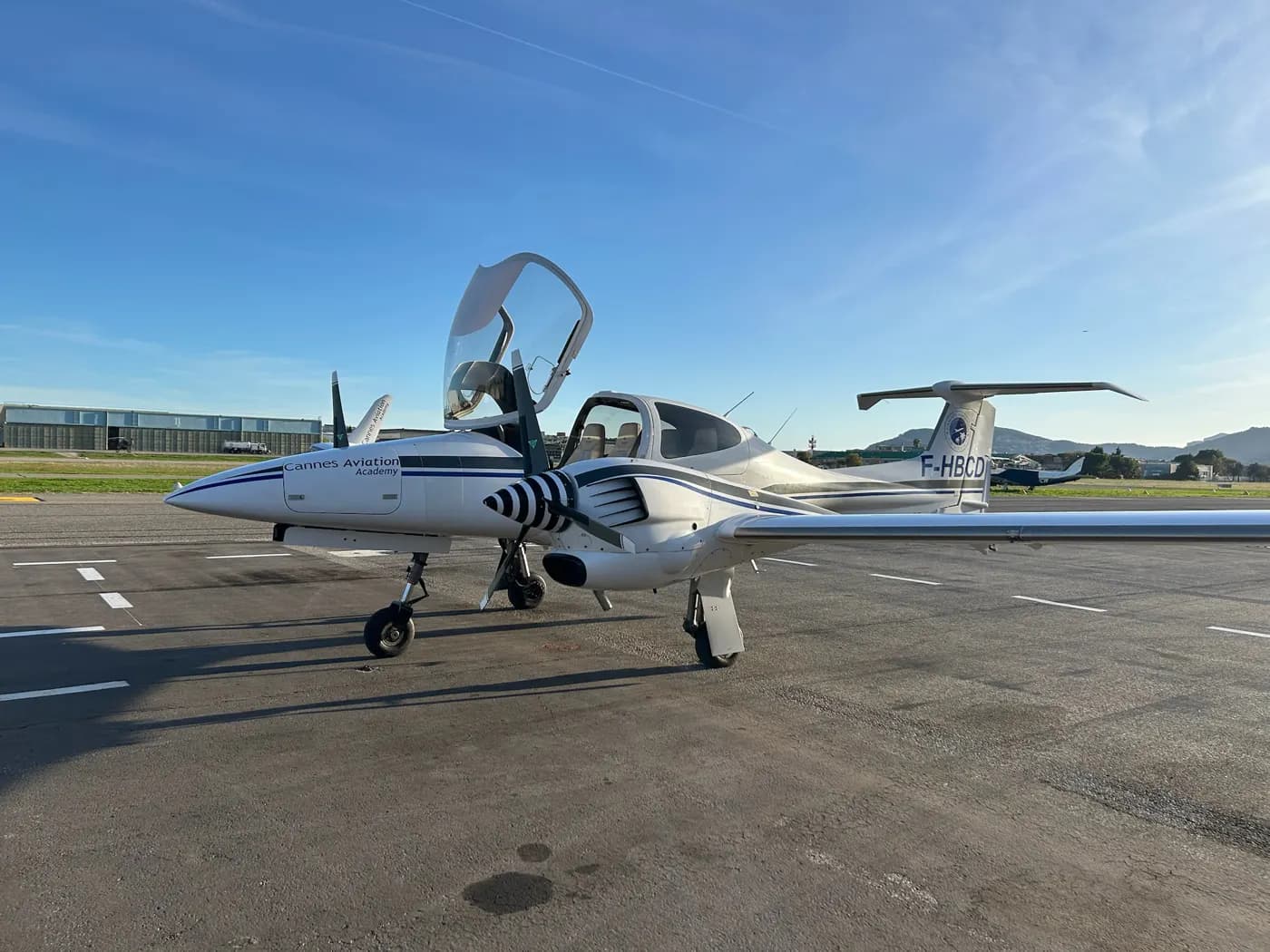 A twin-engine aircraft on the ramp, canopy open